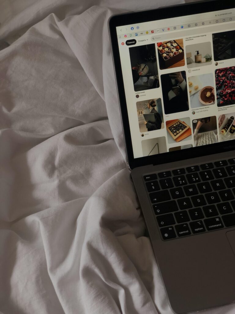 A close-up of a laptop on a bed showing a social media platform.